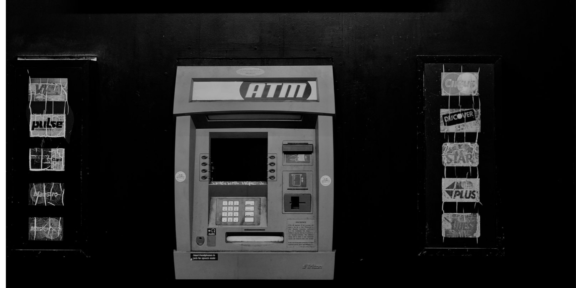 en ATM maskin i mörk husvägg