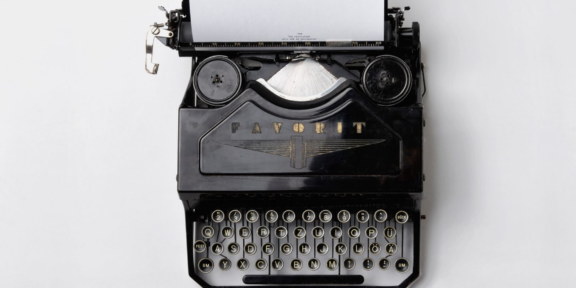 svart äldre skrivmaskin med papper