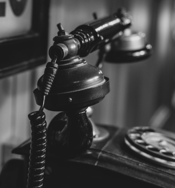 äldre telefon står på bord mot vägg